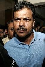 Ijaz Ahmed is surrounded by reporters at a police station